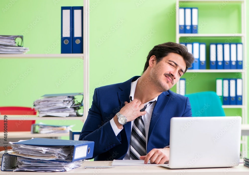 Businessman unhappy with excessive work sitting in the office Businessman unhappy with excessive work sitting in the office