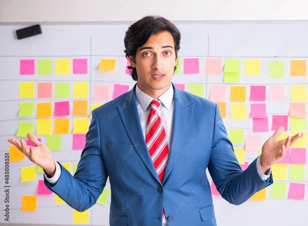 The young handsome employee with many conflicting priorities The young handsome employee with many conflicting priorities