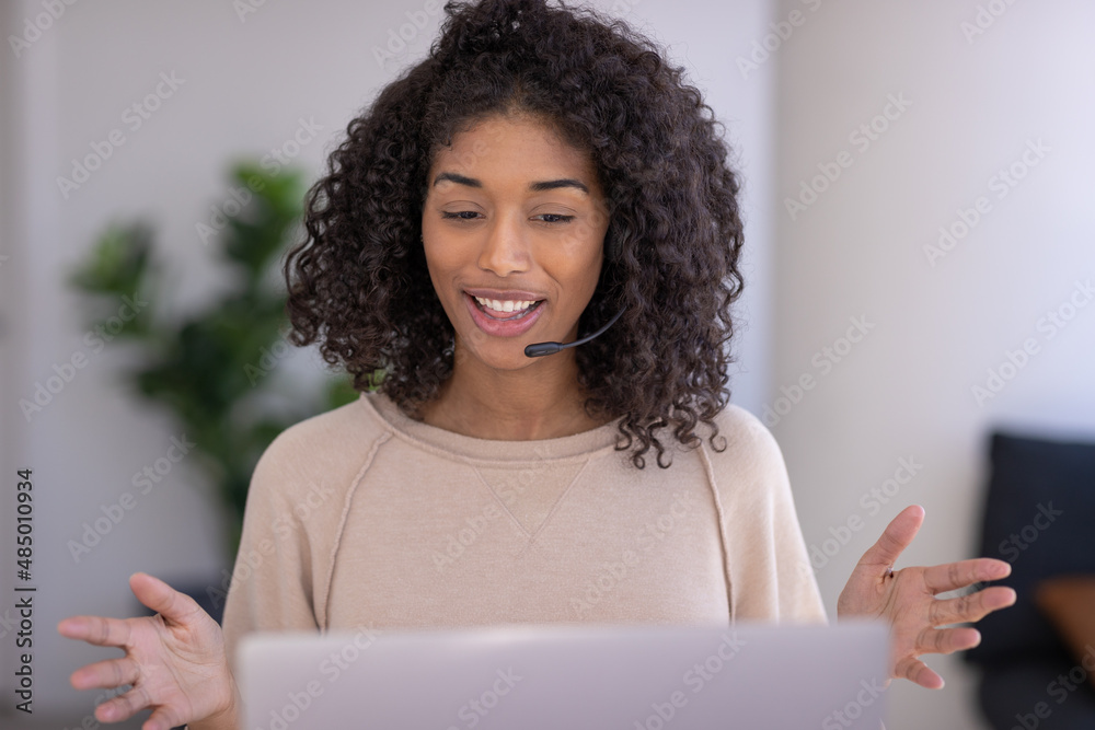 Young black woman at home remote working on laptop computer talking to her colleague Young black woman at home remote working on laptop computer talking to her colleague