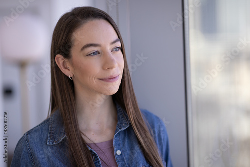 Caucasian woman smiling happy face portrait standing by a window Free Download Caucasian woman smiling happy face portrait standing by a window - GFXLoad