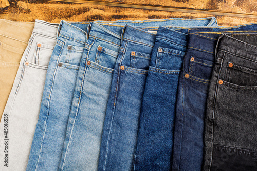 variety of jeans on a wooden background.
