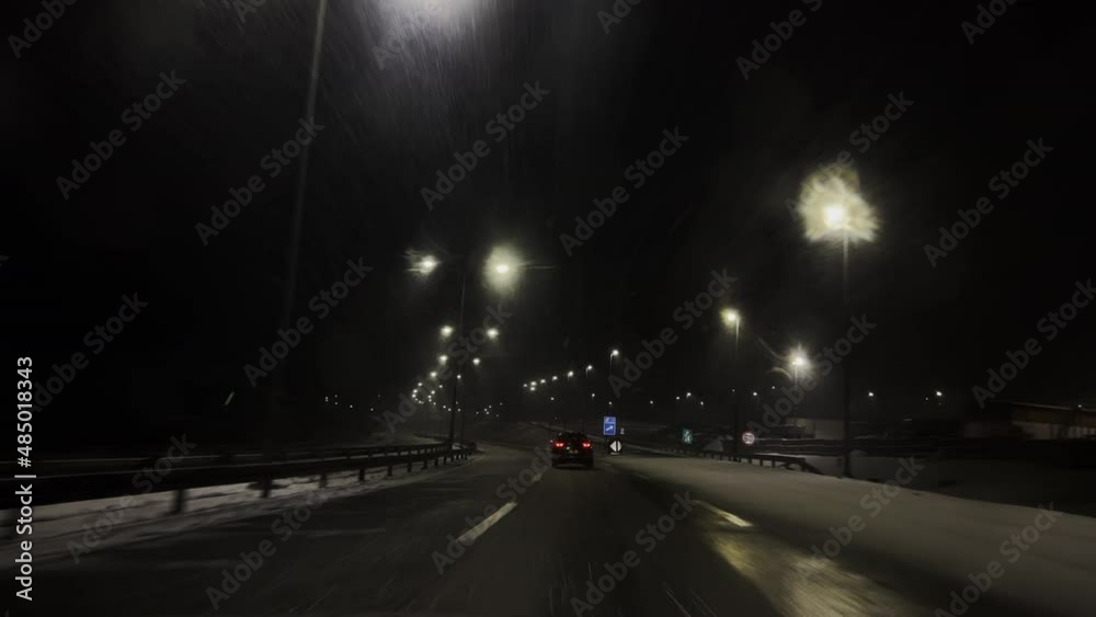 Vehicle driving at winter night road. POV shot.