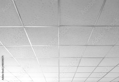 Background and texture of white T bar ceiling tiles with nice light gradation in low angle and perspective view photo