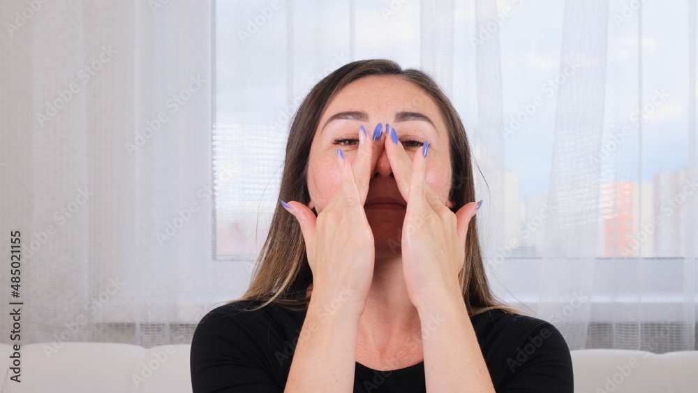 pretty brunette woman makes herself a facial massage along the massage lines and points with her hands. Facial massage. Facial gymnastics. System of exercises improve skin yourself pretty brunette woman makes herself a facial massage along the massage lines and points with her hands. Facial massage. Facial gymnastics. System of exercises improve skin yourself