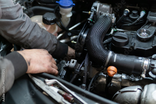 Close up hands of auto mechanic doing car service and maintenance. Services car engine machine. © Dusan