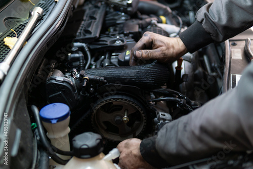 Close up hands of auto mechanic doing car service and maintenance. Services car engine machine.