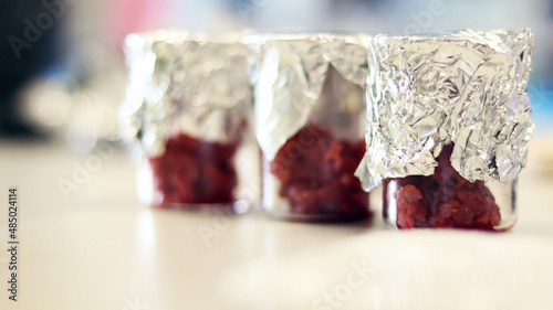 The beakers of meats blood sample cover with aluminum foils on bench laboratory, preparation for biotechnology analysis experiment for anti-biotic test. Food sanitation for consumers determination.