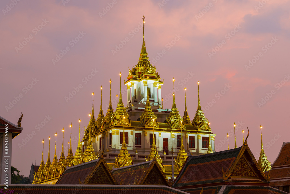 Naklejka premium Top of the old Loha Prasat pagoda of Wat Ratchanatdaram Woravihara Buddhist temple against the evening sky. Bangkok, Thailand