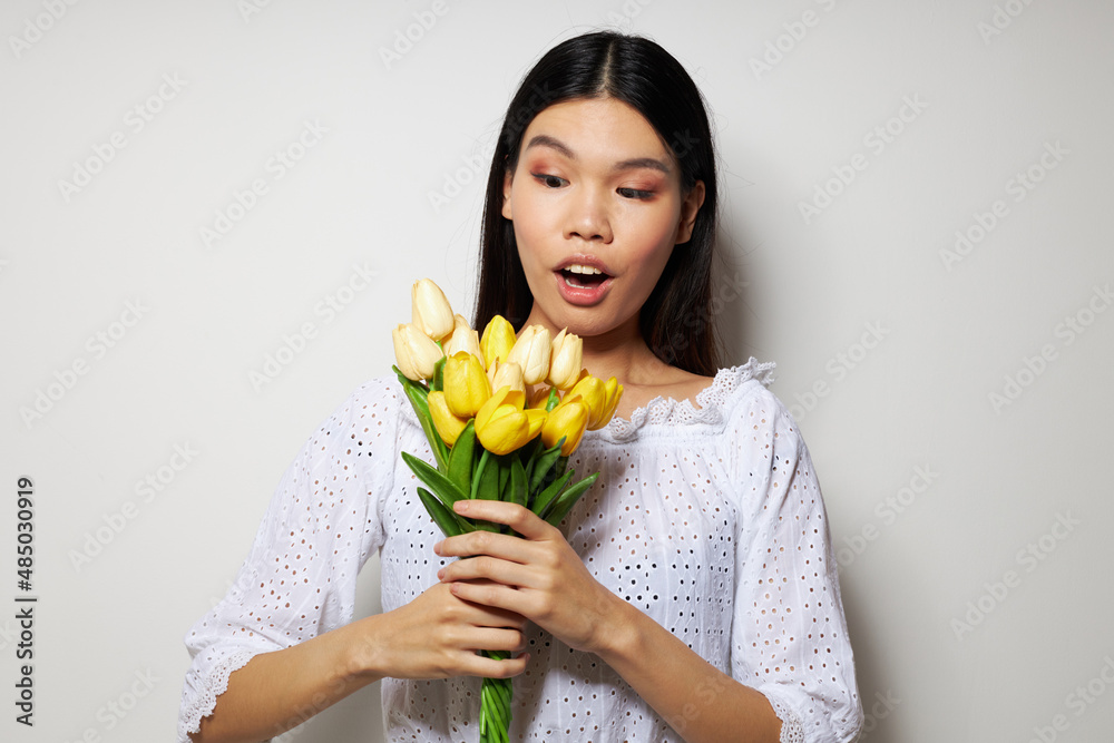 woman with Asian appearance in a white shirt flowers spring posing studio model unaltered woman with Asian appearance in a white shirt flowers spring posing studio model unaltered
