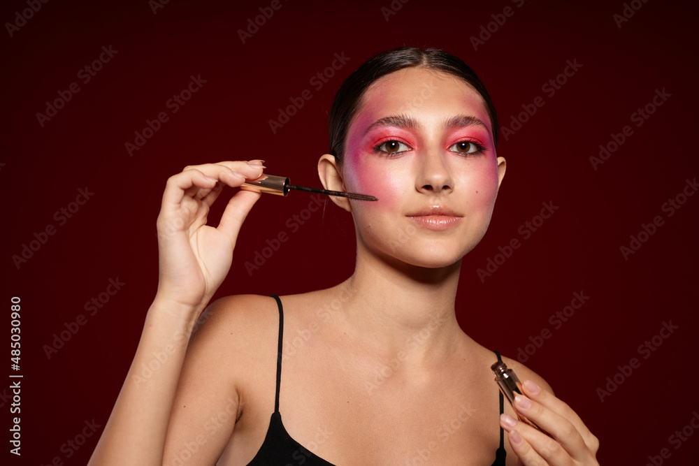Obraz premium Portrait of beautiful young woman makeup emotions cosmetics hair care mascara pink background unaltered