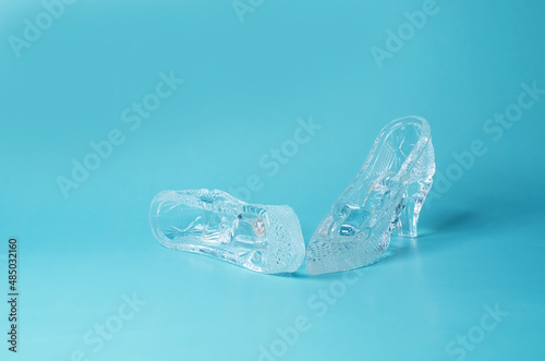 A pair of souvenir crystal shoes on a blue background