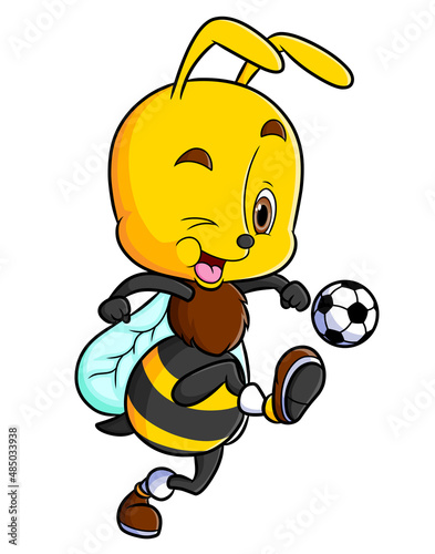 The happy bee is playing the soccer and kicking the ball