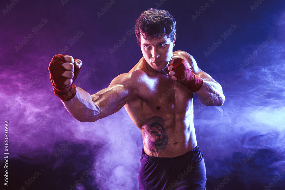 Obraz premium Half length of athlete shirtless boxer who preparing for fight on smoke background. Sport concept