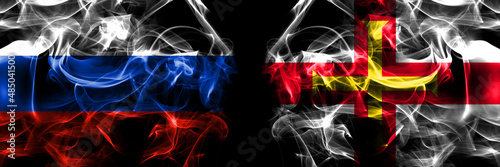Russia, Russian vs United Kingdom, Great Britain, British, Guernsey flags. Smoke flag placed side by side isolated on black background
