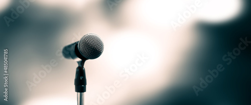 Microphone Public speaking background, Close up microphone on stand for speaker speech presentation stage performance with blur and bokeh light background. photo