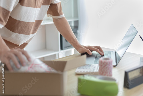 Man is packing in the mailbox to prepare to deliver it to the customer, Working at home and owning businesses, Online shopping SME entrepreneur, packing box, Sell online, freelance working.