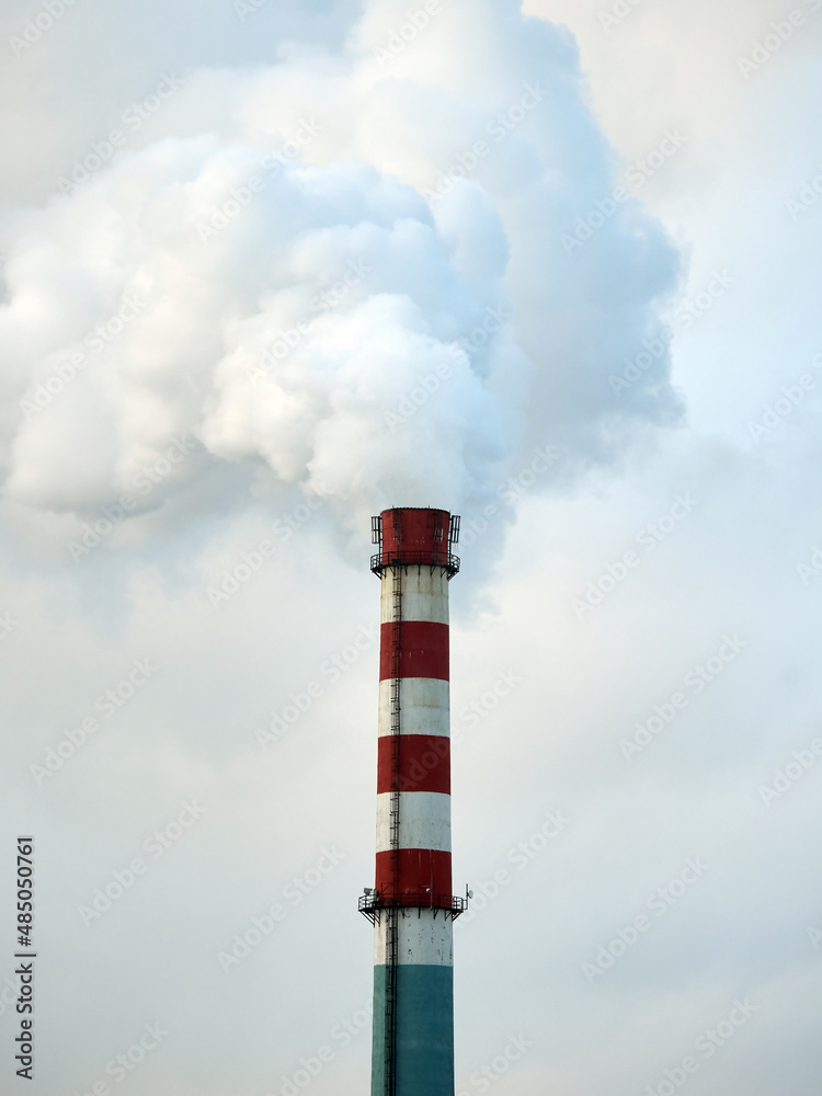 Environmental pollution. The tall chimney releases smoke and steam. Environmental pollution. The tall chimney releases smoke and steam.
