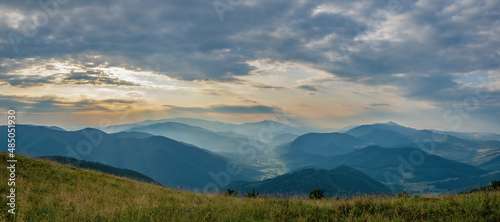 Summer evening in the mountains. Panorama of a mountain landscape in the Carpathians. View of the valley from the top of Mount Bozova