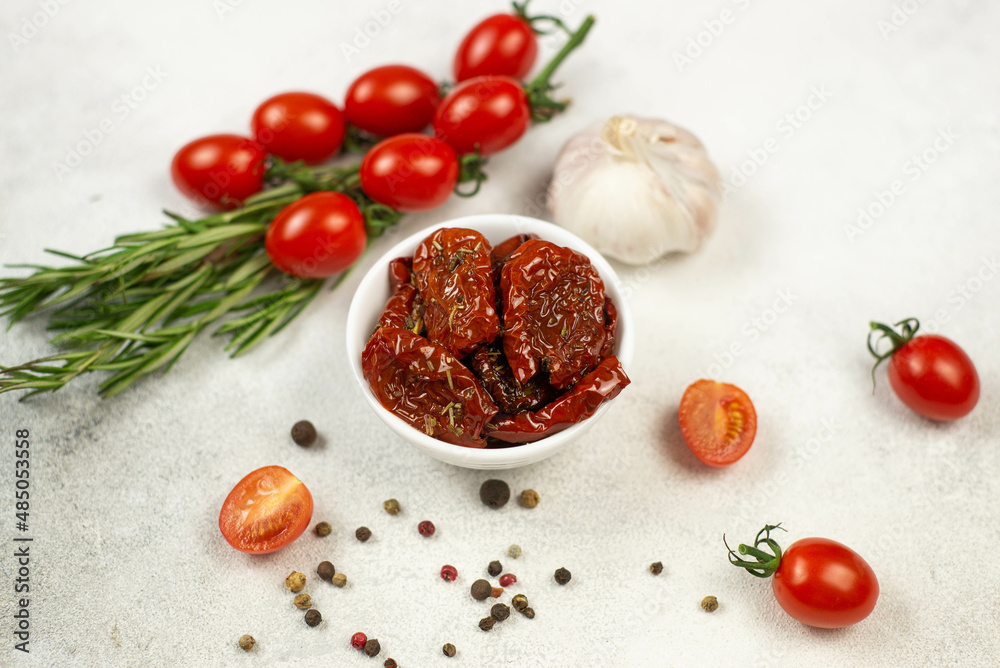 Sun dried tomatoes with fresh herbs, spices, tjmatoes and garlik. Grey background. Top viewer. Sun dried tomatoes with fresh herbs, spices, tjmatoes and garlik. Grey background. Top viewer.