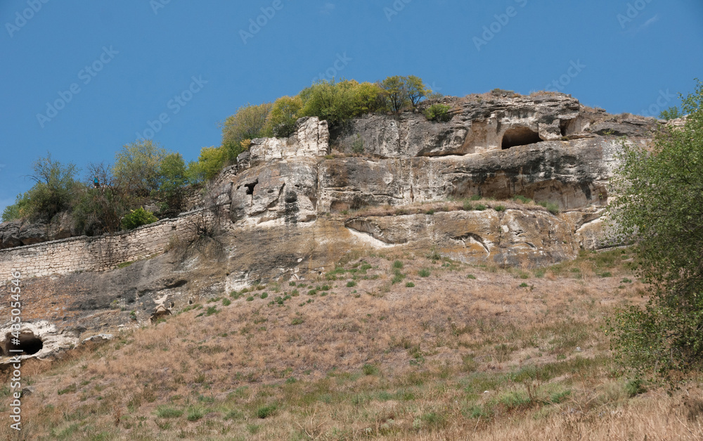 Caves in rocky slopes of Chufut-Kale, medieval city-fortress in Crimean Mountains, national monument of Crimean Karaites, now lies in ruins, central Crimea Caves in rocky slopes of Chufut-Kale, medieval city-fortress in Crimean Mountains, national monument of Crimean Karaites, now lies in ruins, central Crimea