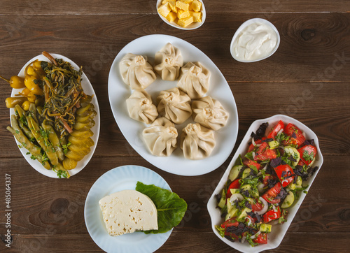 Georgian cuisine foodset from khinkali, cheese, pickles and  salad,on the table. Top view. photo