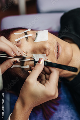 Extreme close up shot of eyelash extension procedure. Cosmetics and body care concept. Shallow depth of field and selective focus.