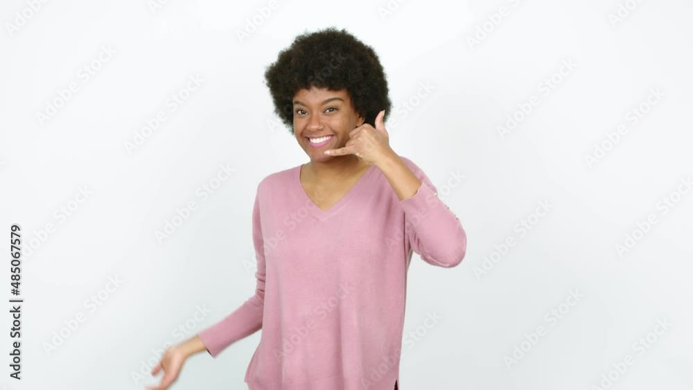 Young African American woman making phone gesture and speaking with someone. Call me back sign over isolated background Young African American woman making phone gesture and speaking with someone. Call me back sign over isolated background