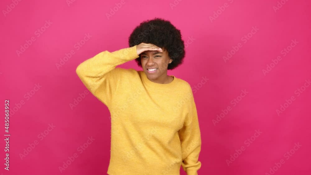 Young African American woman looking far away with hand to look something over isolated background Young African American woman looking far away with hand to look something over isolated background