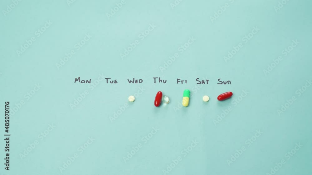 Scattered Pills By Days Of the Week, Close-Up Of Male Fingers Taking Pills For Tuesday Scattered Pills By Days Of the Week, Close-Up Of Male Fingers Taking Pills For Tuesday
