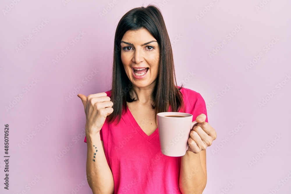 Young hispanic woman drinking a cup of coffee pointing finger to one self smiling happy and proud Young hispanic woman drinking a cup of coffee pointing finger to one self smiling happy and proud