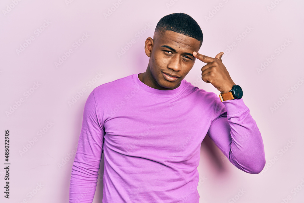 Young black man wearing casual pink sweater pointing unhappy to pimple on forehead, ugly infection of blackhead. acne and skin problem Young black man wearing casual pink sweater pointing unhappy to pimple on forehead, ugly infection of blackhead. acne and skin problem
