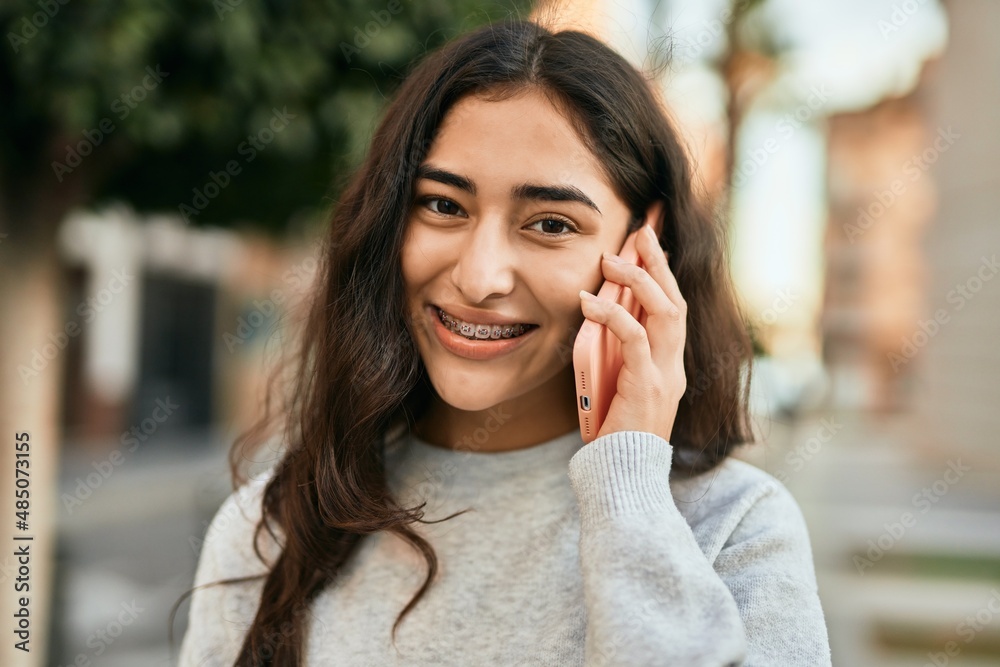 Young middle east girl smiling happy talking on the smartphone at the city. Young middle east girl smiling happy talking on the smartphone at the city.
