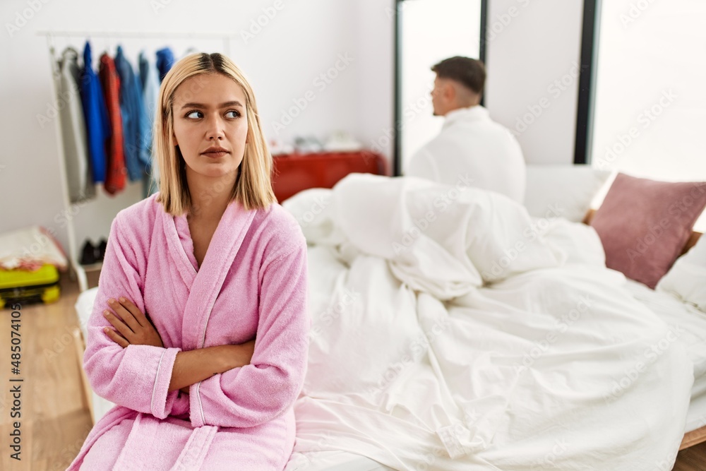 Young caucasian couple in conflict sitting on the bed at home.