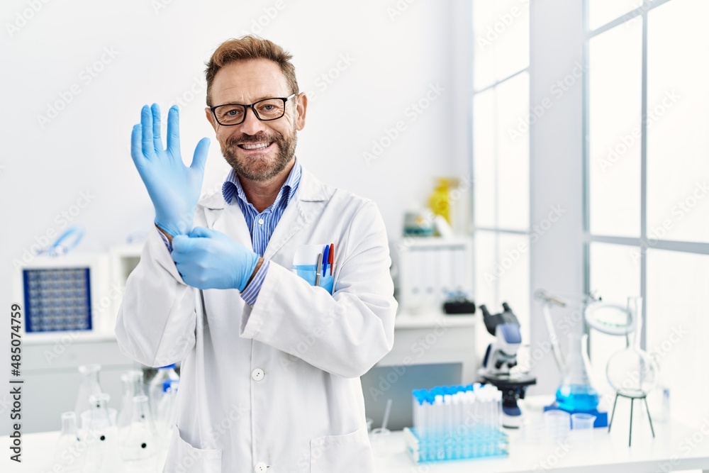Middle age man working at scientist laboratory smiling with a happy and cool smile on face. showing teeth. Middle age man working at scientist laboratory smiling with a happy and cool smile on face. showing teeth.