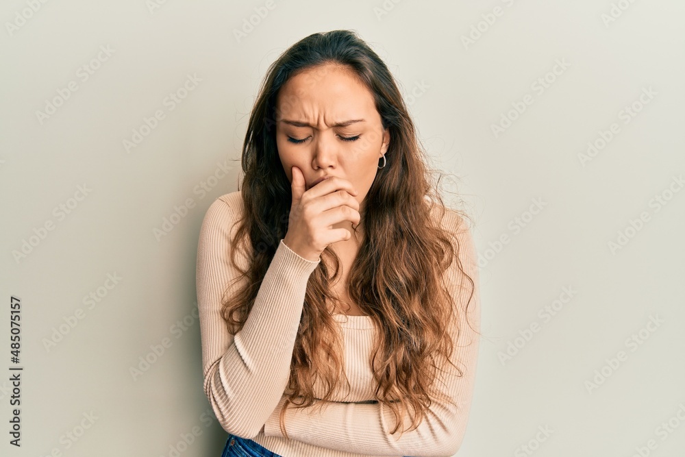Young hispanic girl wearing casual clothes feeling unwell and coughing as symptom for cold or bronchitis. health care concept. Young hispanic girl wearing casual clothes feeling unwell and coughing as symptom for cold or bronchitis. health care concept.