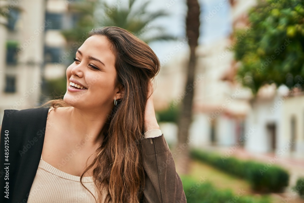 Young hispanic woman smiling happy standing at the city.