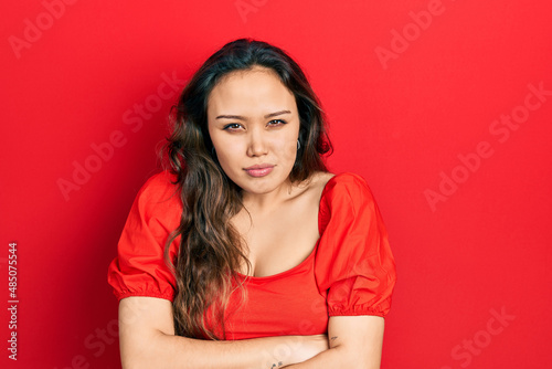 Young hispanic girl wearing casual clothes skeptic and nervous, disapproving expression on face with crossed arms. negative person.