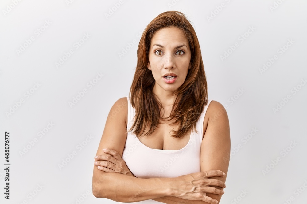 Middle age hispanic woman standing over isolated background afraid and shocked with surprise expression, fear and excited face. Middle age hispanic woman standing over isolated background afraid and shocked with surprise expression, fear and excited face.