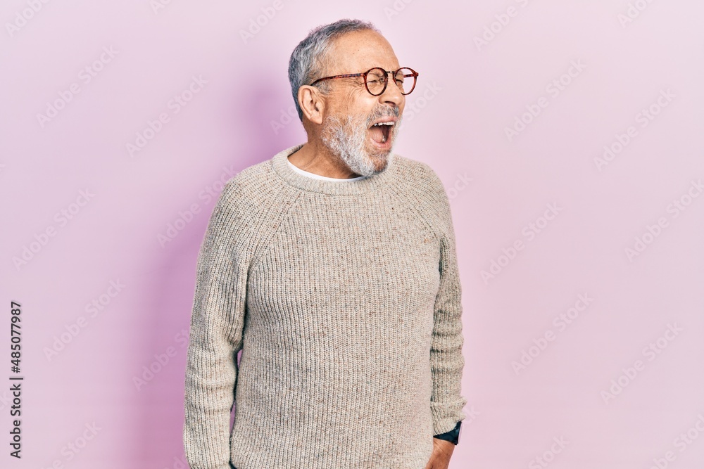 Handsome senior man with beard wearing casual sweater and glasses angry and mad screaming frustrated and furious, shouting with anger. rage and aggressive concept. Handsome senior man with beard wearing casual sweater and glasses angry and mad screaming frustrated and furious, shouting with anger. rage and aggressive concept.