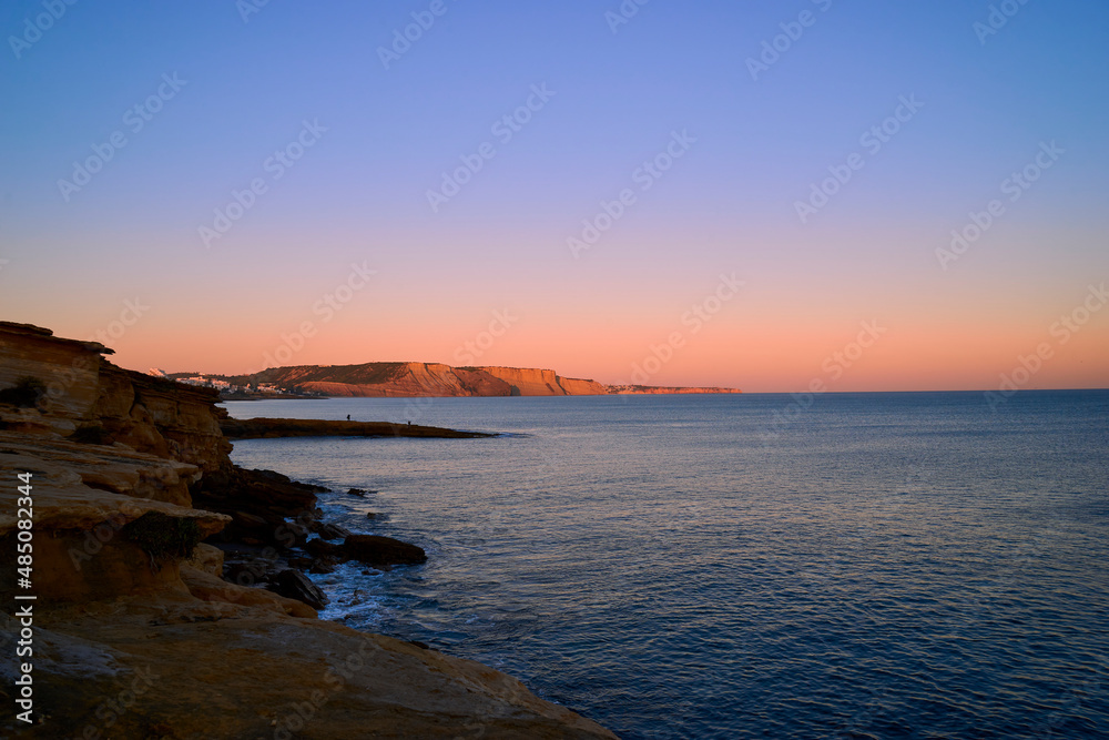 Sonnenuntergang über der Felsküste am Atlantik zwischen Burgau und Luz westlich von Lagos, Algarve, Barlavento, Westalgarve, Felsalgarve, Distrikt Faro, Portugal, Europa