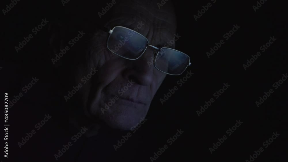 Image from computer screen reflecting in glasses of mature businessman working late in night at home or office room close up Image from computer screen reflecting in glasses of mature businessman working late in night at home or office room close up