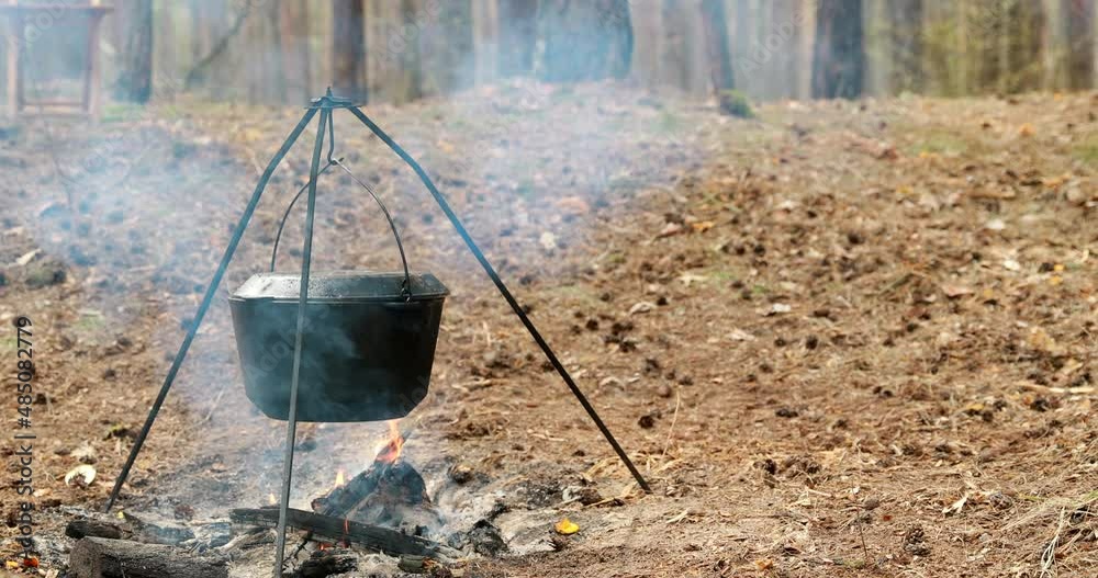 Old Retro Camp Saucepan Boiled Water For Soup Preparation On A Fire In Forest. Flame Fire Bonfire. Old Retro Camp Saucepan Boiled Water For Soup Preparation On A Fire In Forest. Flame Fire Bonfire.