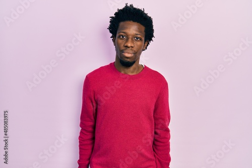 Young african american man wearing casual clothes relaxed with serious expression on face. simple and natural looking at the camera.