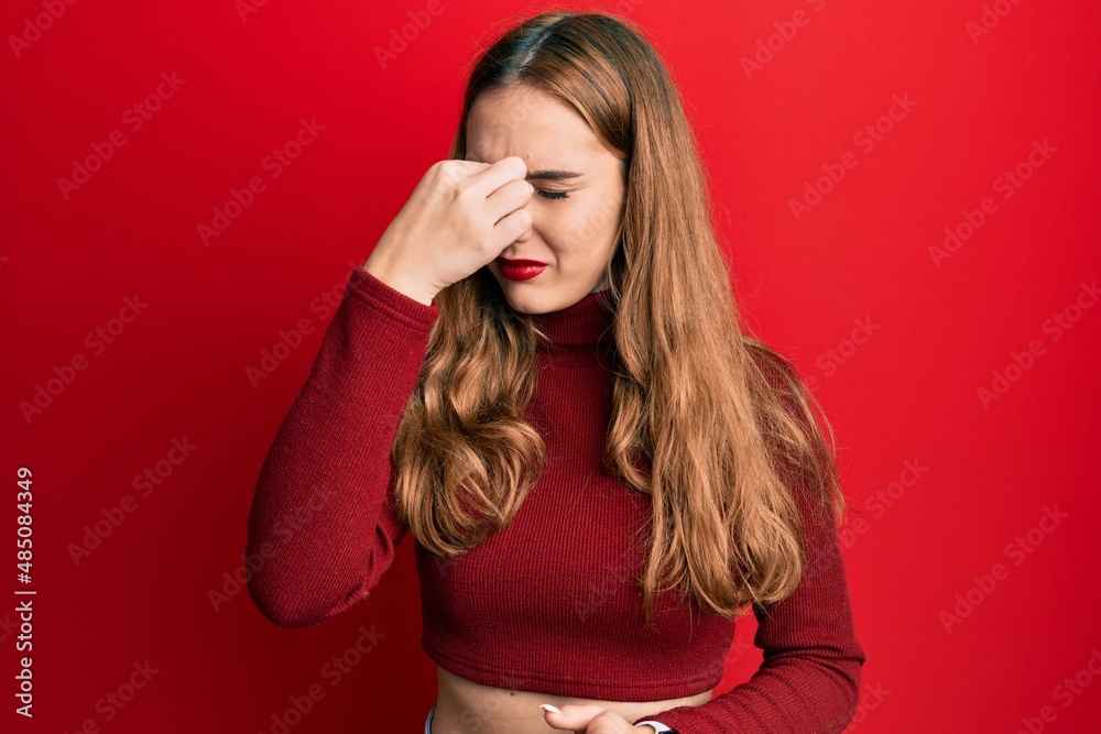 Fototapeta premium Young blonde woman wearing turtleneck sweater tired rubbing nose and eyes feeling fatigue and headache. stress and frustration concept.