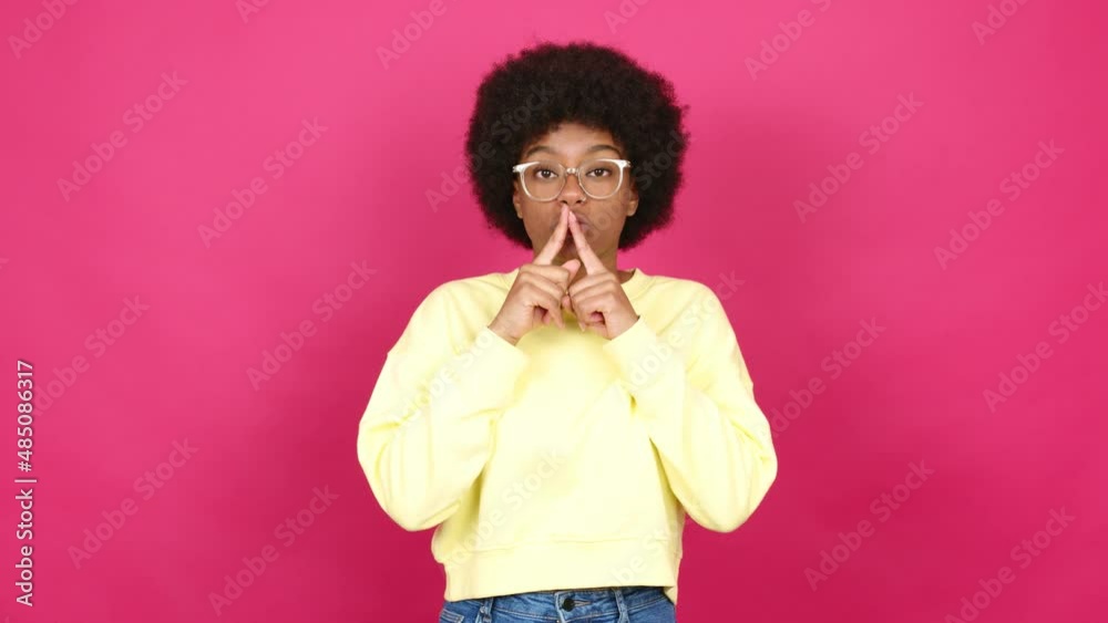 Young African American woman with glasses and doing silence gesture Young African American woman with glasses and doing silence gesture