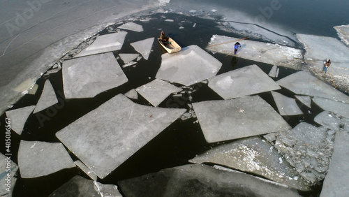Farmers use boats to move ice on the water, North China
