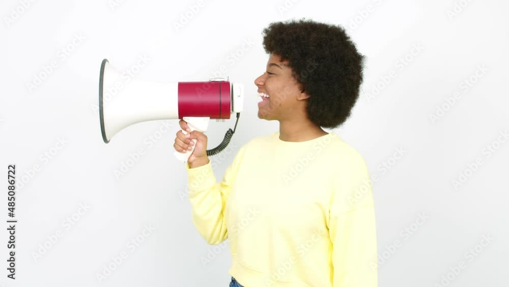 Young African American woman holding a megaphone and shouting over isolated background Young African American woman holding a megaphone and shouting over isolated background