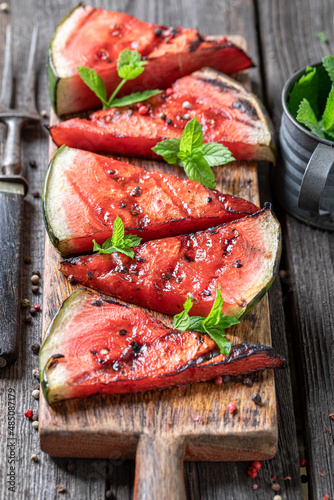 Homemade roasted watermelon on grill grate with fire.