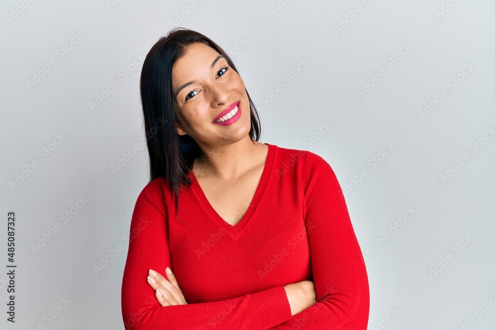 Young latin woman wearing casual clothes happy face smiling with crossed arms looking at the camera. positive person. Young latin woman wearing casual clothes happy face smiling with crossed arms looking at the camera. positive person.