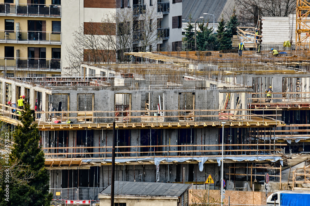 Construction workers install formwork and iron rebars or reinforcing bars for reinforced concrete partitions at residential building construction site Construction workers install formwork and iron rebars or reinforcing bars for reinforced concrete partitions at residential building construction site